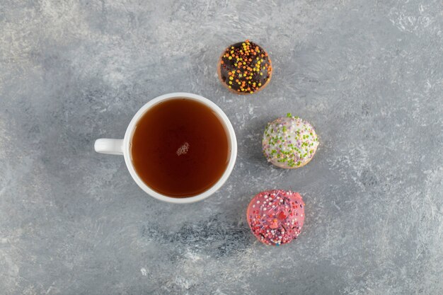 Una taza de té blanco con pequeñas y deliciosas donas.