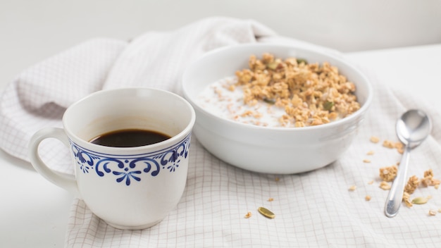 Taza de té blanco; tazón de fuente de gachas de avena en el mantel