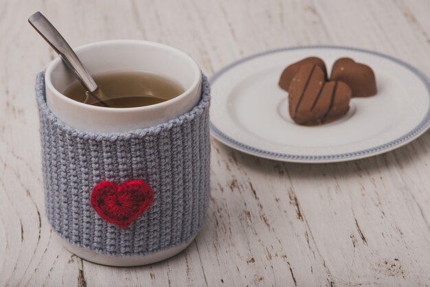 Taza de té con bombones en forma de corazón