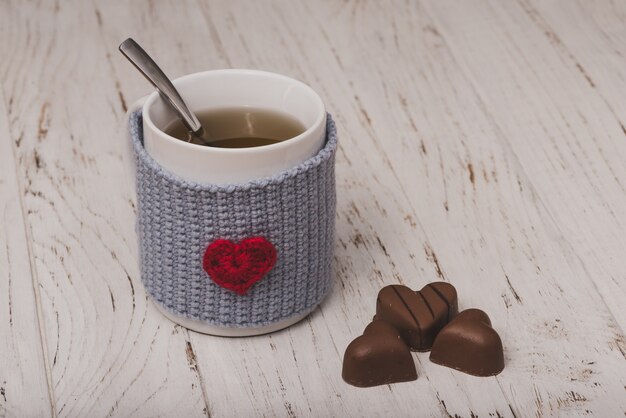 Taza de té con bombones en forma de corazón