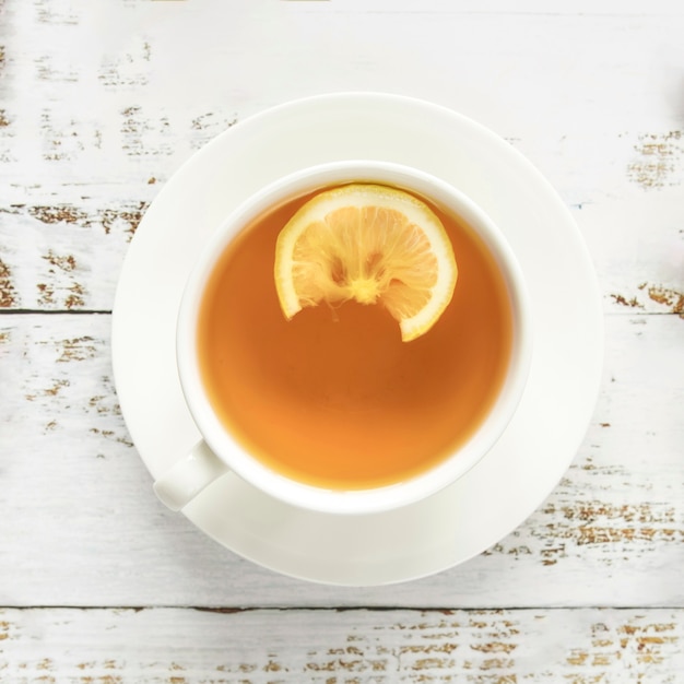 Taza de té caliente en superficie de madera