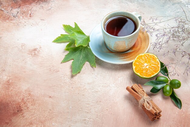 taza de té con canela y limón a la luz