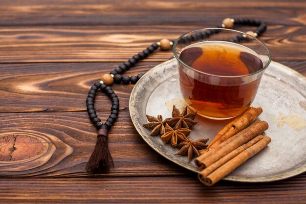 Taza de té con canela y rosario.