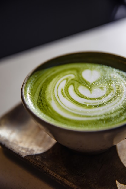 Taza de té de cerámica blanca sobre superficie marrón