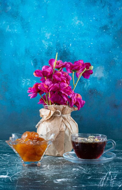 Una taza de té con confitura de higos en el platillo. Foto de alta calidad