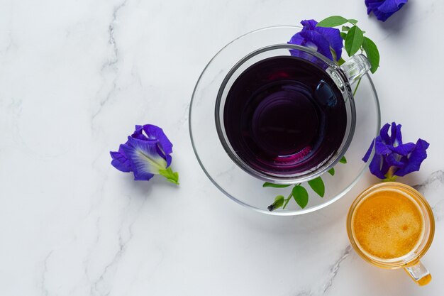 Taza de té de flor de guisante de mariposa con miel en la mesa