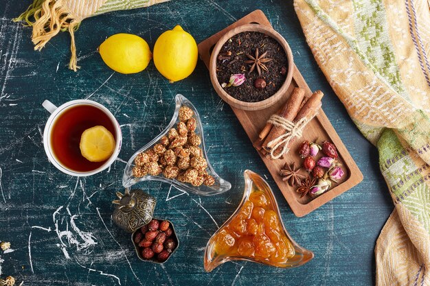 Una taza de té con frutas, dulces y especias.