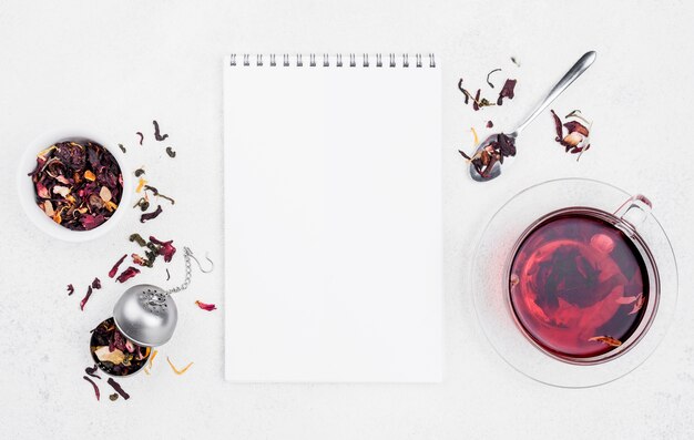 Foto gratuita taza con té de hierbas al lado del cuaderno