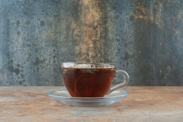 Una taza de té de hierbas aromáticas sobre fondo de mármol