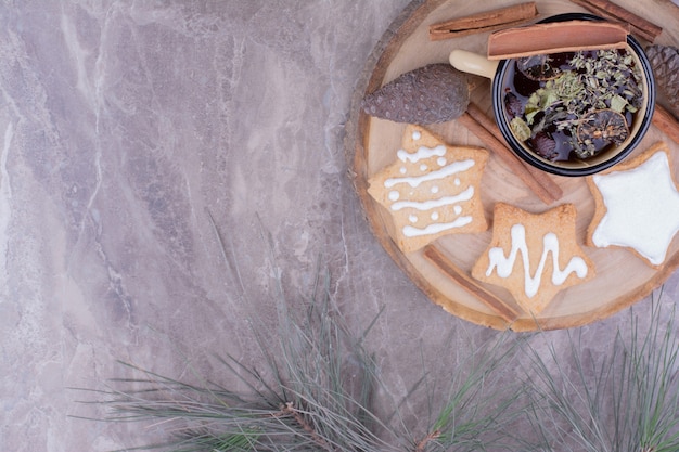 Una taza de té de hierbas con pan de jengibre sobre una tabla de madera