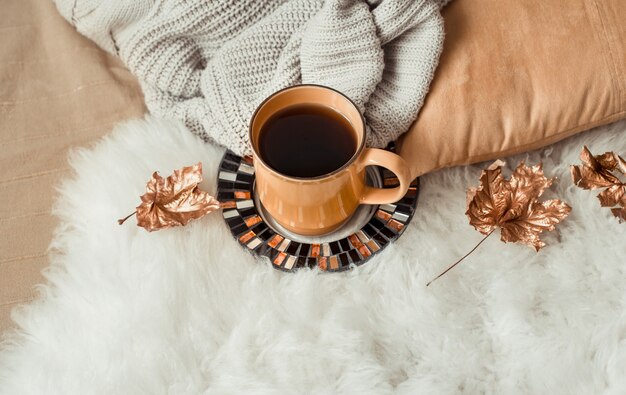 Taza de té con hojas de otoño y suéter