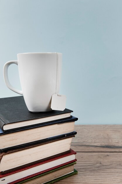 Taza de té en libros con espacio de copia