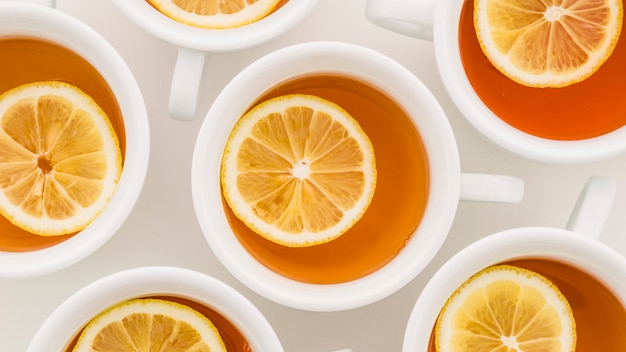 Taza de té de limón y jengibre limón sobre fondo blanco
