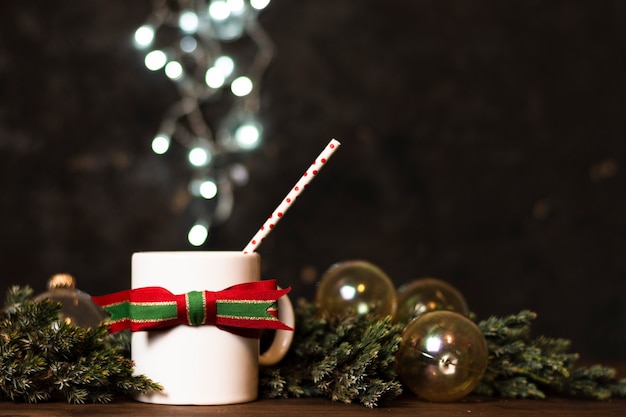 Taza de té con luces de navidad en el fondo