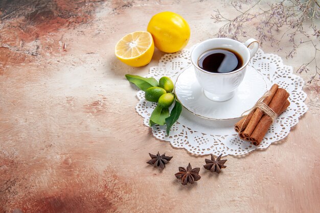 Una taza de té negro en una servilleta decorada en blanco