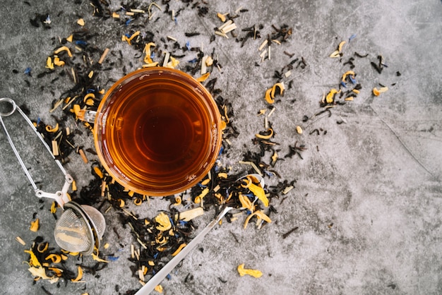 Taza de té plana con infusor sobre fondo de mármol