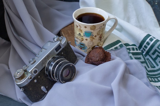 Foto gratuita una taza de té con un praliné de chocolate sobre la mesa.