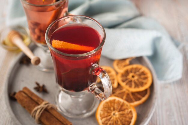 Taza de té con rodajas de naranja y canela.