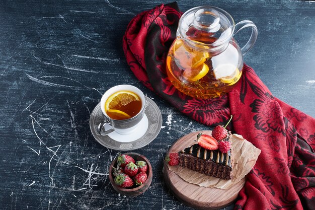 Una taza de té con tarta de limón y chocolate.