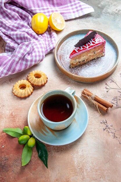 una taza de té una taza de té plato de pastel galletas canela mantel de limón