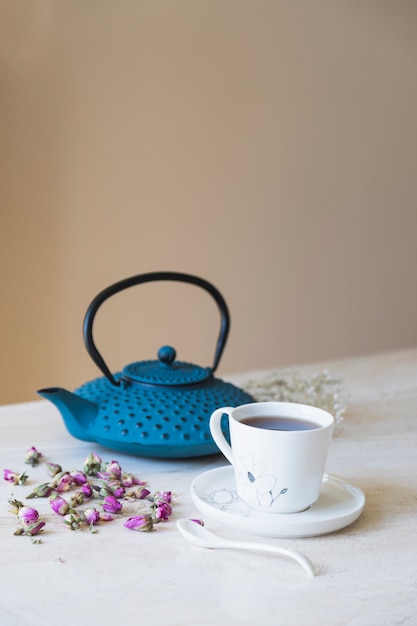 Foto gratuita taza de té con tetera y elementos de desayuno