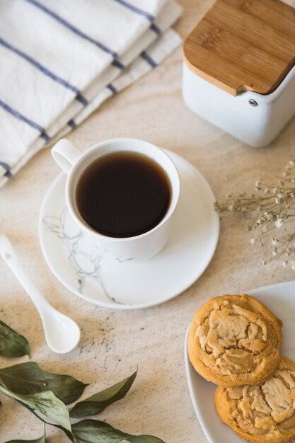 Taza de té con tetera y elementos de desayuno