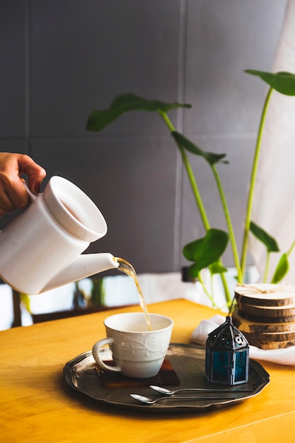 Taza de té con tetera y elementos de desayuno