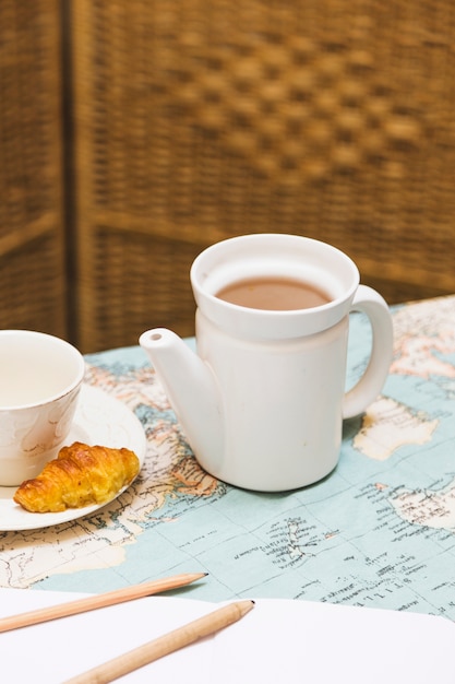 Foto gratuita taza de té con tetera y elementos de desayuno