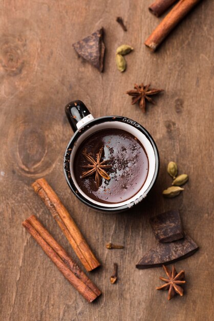 Taza de vista superior con chocolate caliente y canela en la mesa