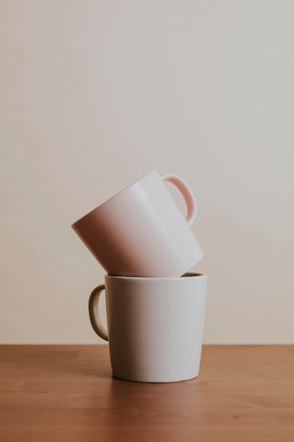 Tazas de café de cerámica de color tono tierra sobre mesa de madera