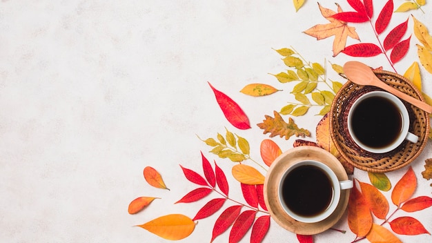 Tazas de café y coloridas hojas de otoño copian espacio