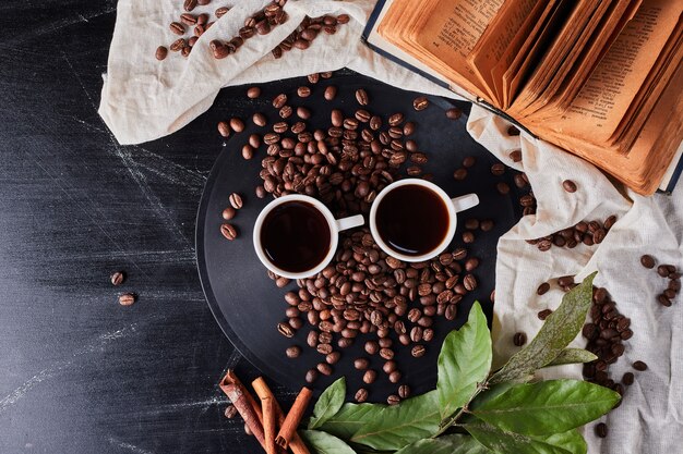 Tazas de café con frijoles alrededor.