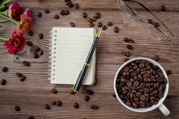 Tazas de café y granos de café sobre la mesa, día internacional del concepto de café