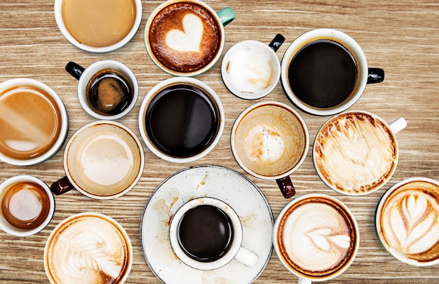 Tazas de café surtidas en una mesa de madera