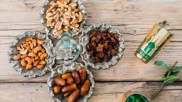 Tazas cerca de la ramita de la planta, frutos secos y nueces a bordo