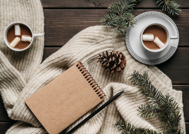 Foto gratuita tazas de chocolate caliente de vista superior con agenda en blanco