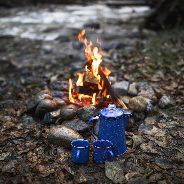 Tazas y olla cerca del fuego