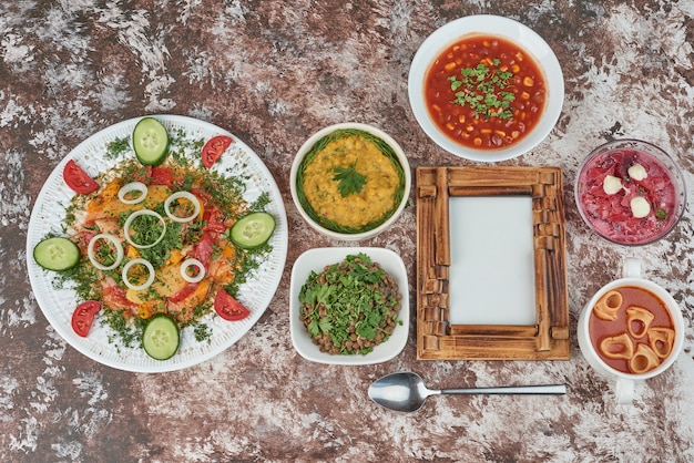 Tazas de sopa de ensalada de verduras sobre la mesa.