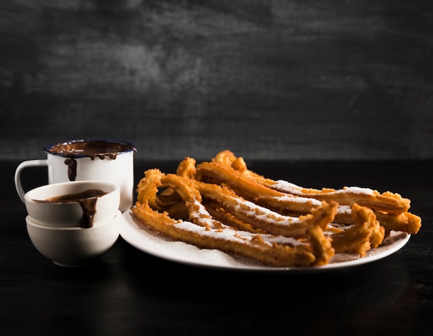 Tazas sucias con chocolate derretido y churros