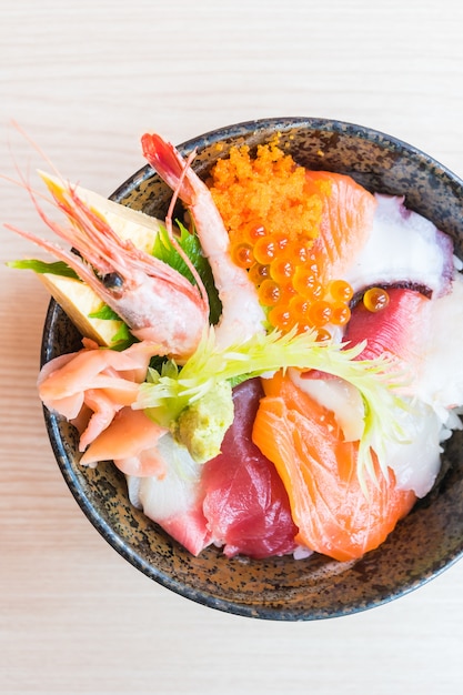Tazón de arroz japonés con mariscos sashimi en la parte superior