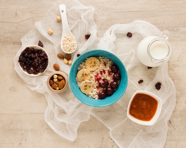 Tazón de avena plano con frutas, nueces y leche