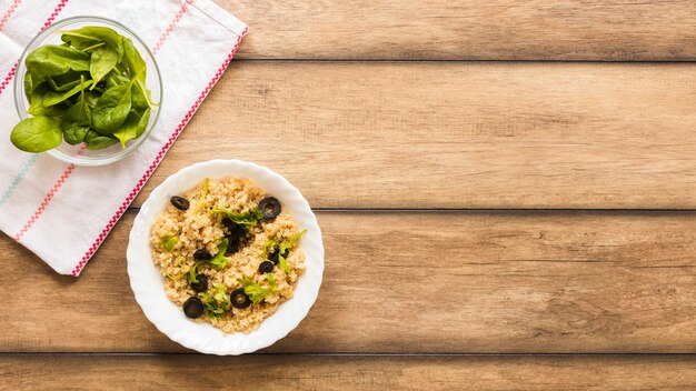 Tazón de avena saludable adornado con hojas de albahaca y oliva para el desayuno