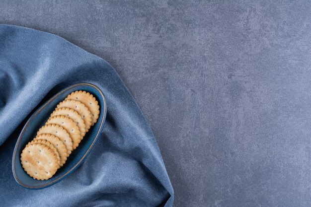 Un tazón azul de galletas de mantequilla para el té sobre un mantel.