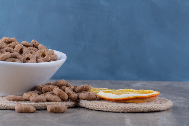 Un tazón blanco de anillos de cereal de chocolate saludables para el desayuno