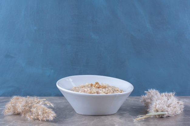 Foto gratuita un tazón blanco con sabrosas gachas de avena saludables para el desayuno.