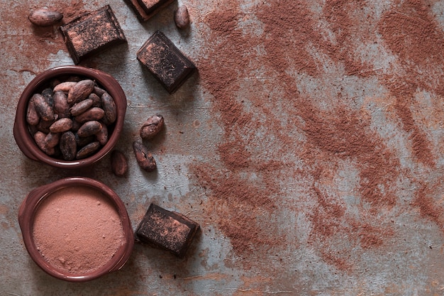 Foto gratuita tazón de cacao en polvo y frijoles con trozos de chocolate