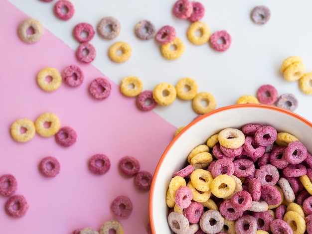 Tazón de cereal en un rincón rodeado de aros de frutas