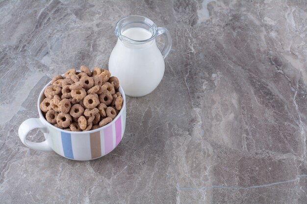 Foto gratuita un tazón de cereales de chocolate saludables suena con un tarro de cristal de leche.