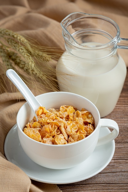 Foto gratuita en un tazón de cereales y leche sobre fondo de madera oscura.