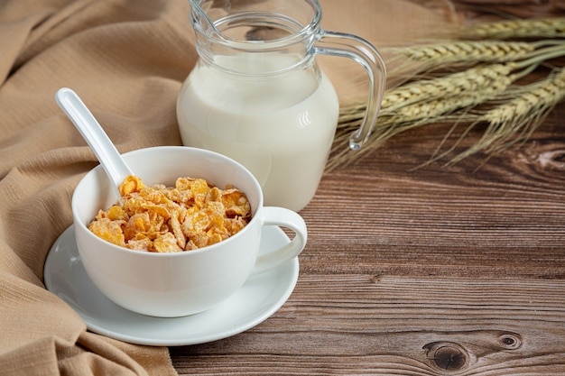 En un tazón de cereales y leche sobre fondo de madera oscura.